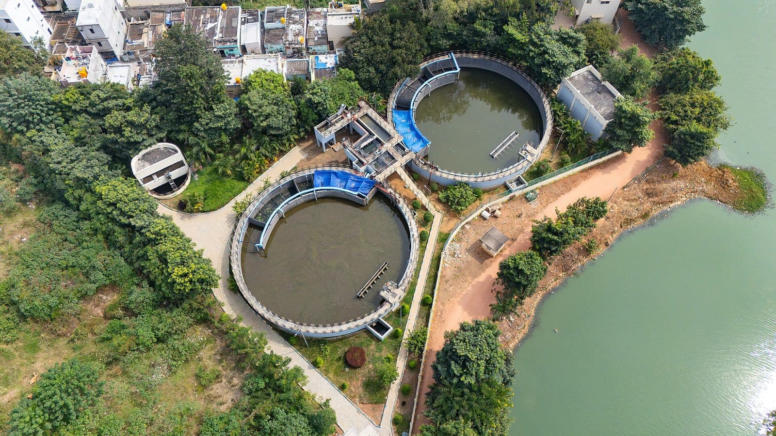 Aerial view of a sewage treatment plant next to a lake